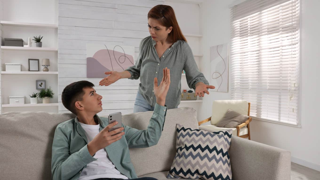 Mother scolding her son while he using smartphone at home.