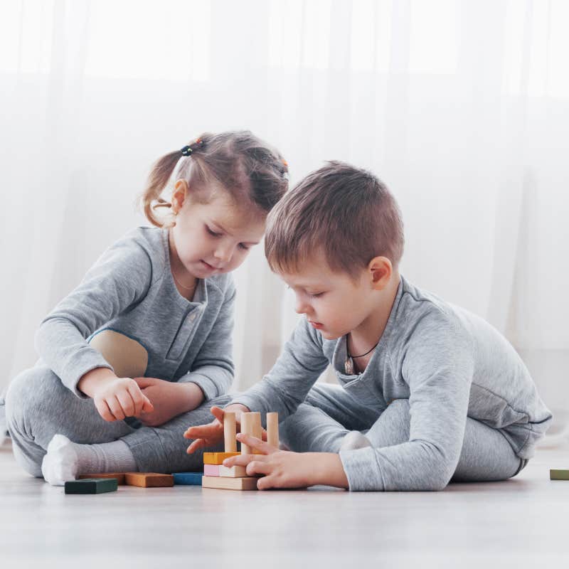 Children play with a toy on the floor of the children's room