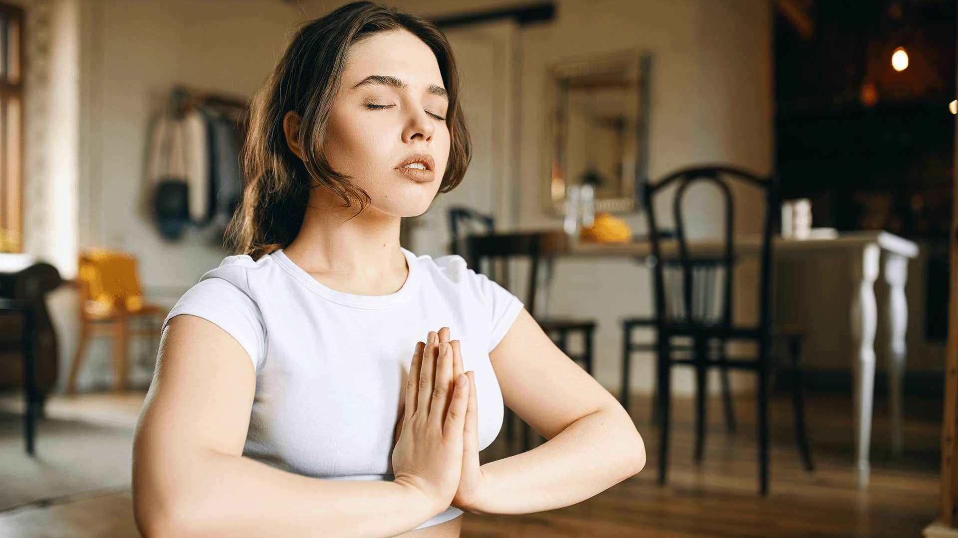 woman in white shirt practicing yoga and meditation