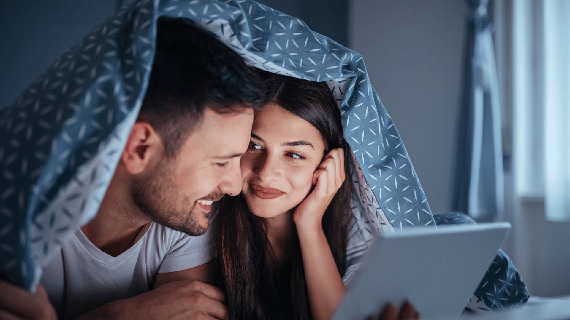 couple watching romance movie under the covers