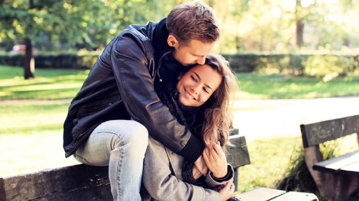 couple hugging on a park bench