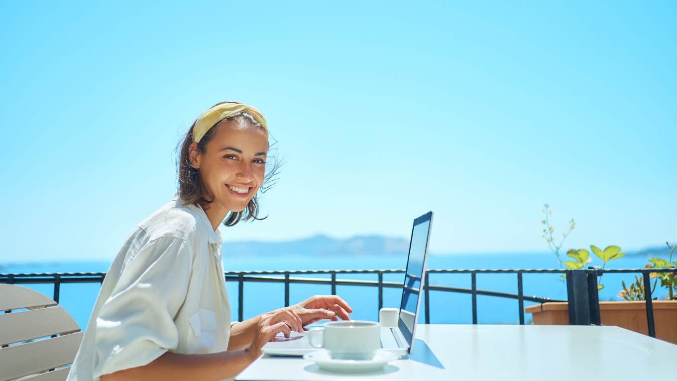 woman on laptop by the beach 