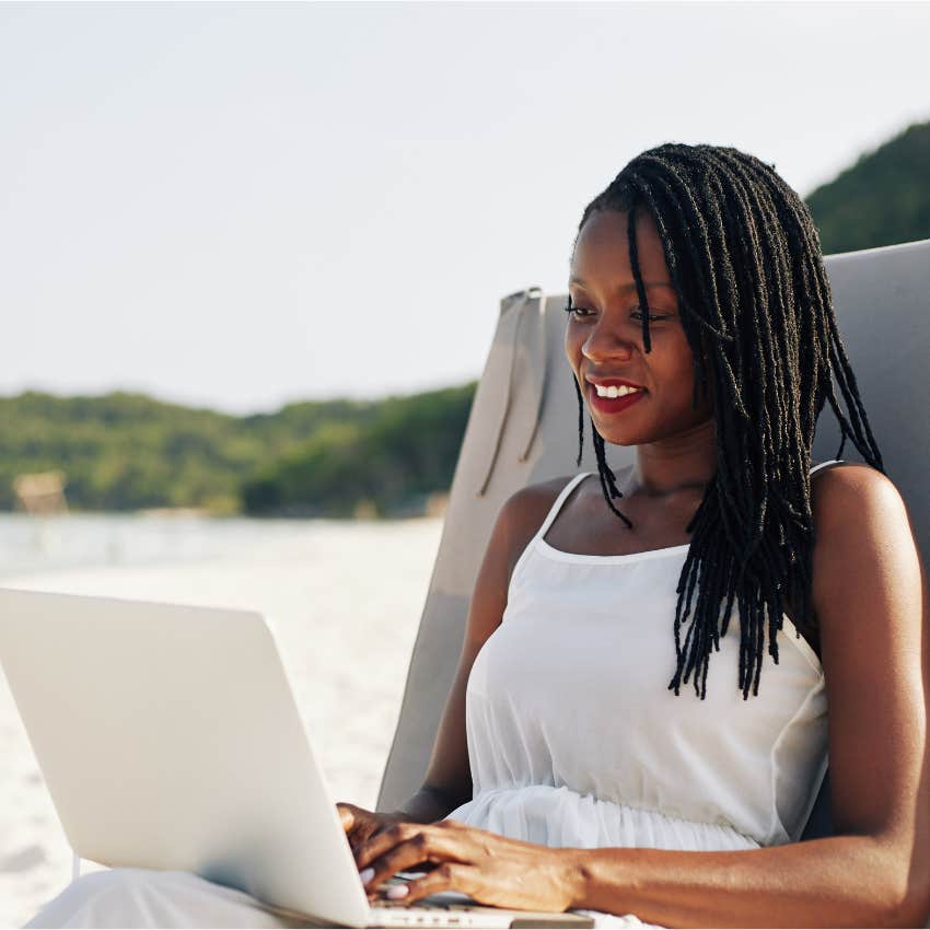 woman working on laptop at the beach