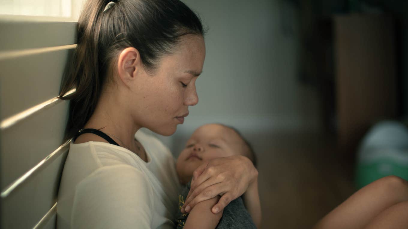 sad exhausted mother home alone with her baby