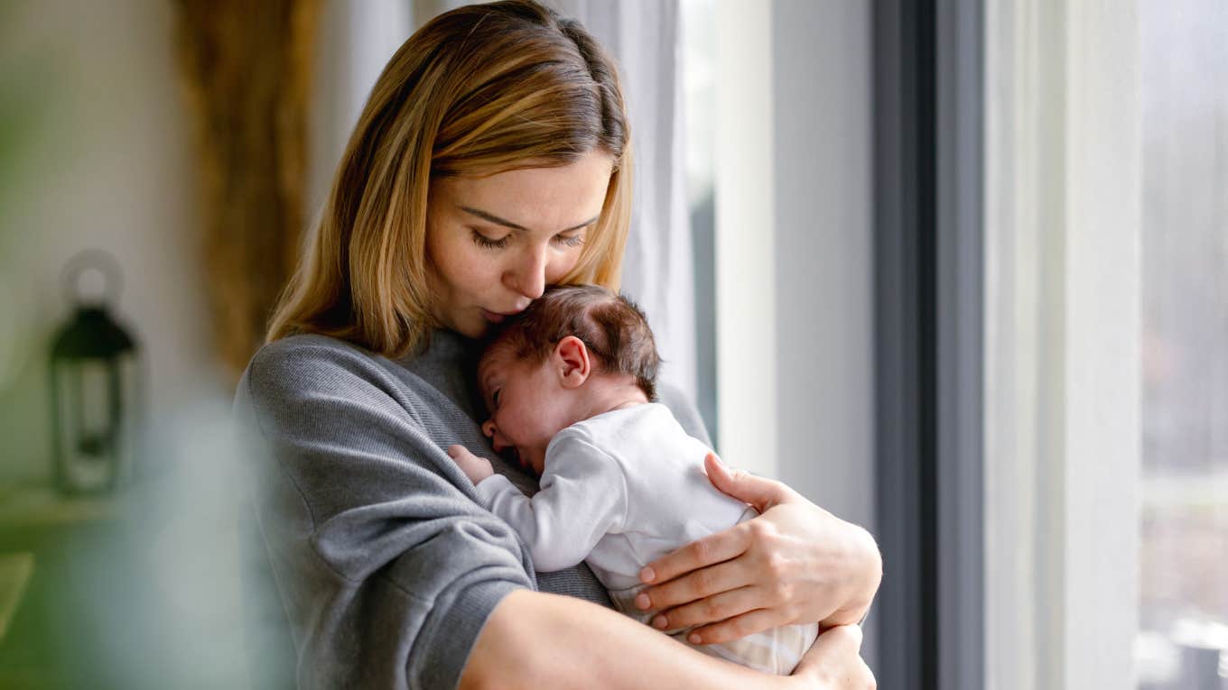 Loving mother hugs her little baby at home