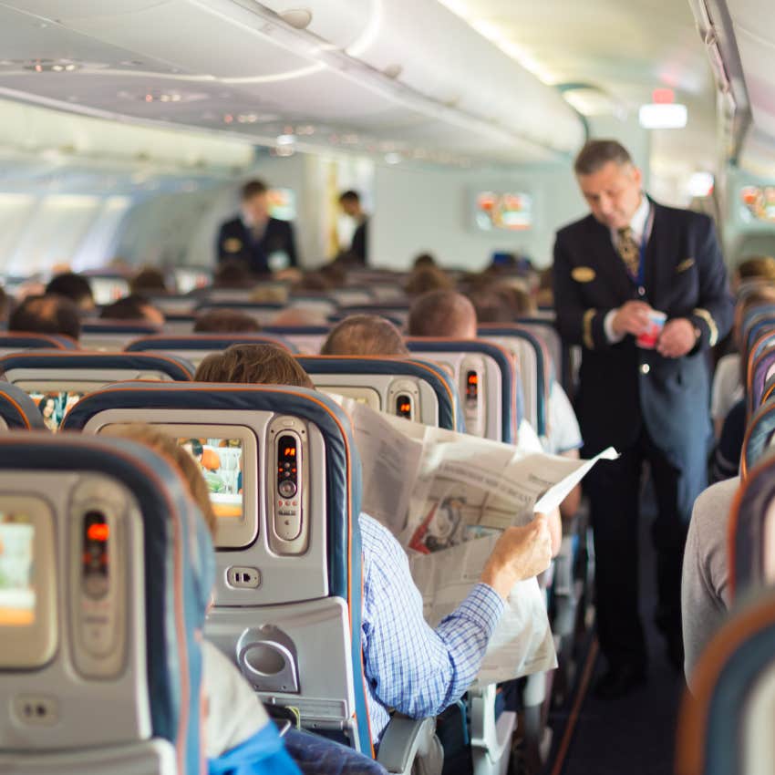 flight attendant in the aisle of a flight