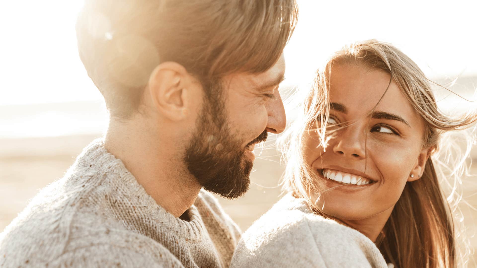 man holding woman while woman looks at man while smiling