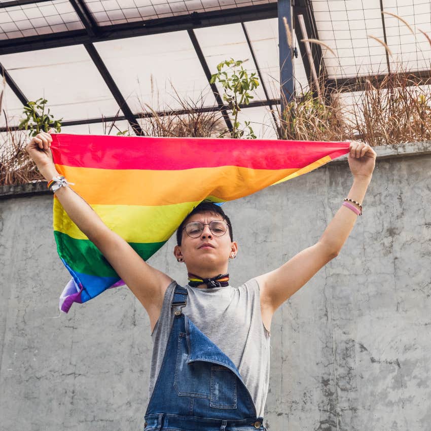 Demiboy holding gay flag