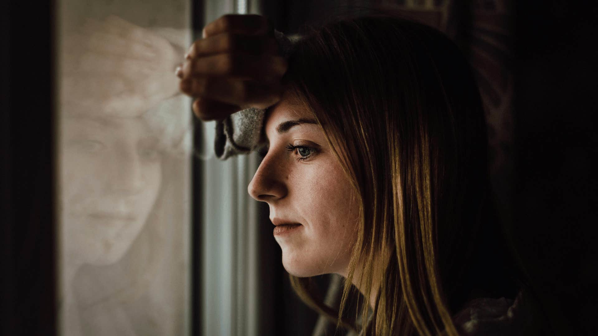 intelligent woman reflecting and looking out of window