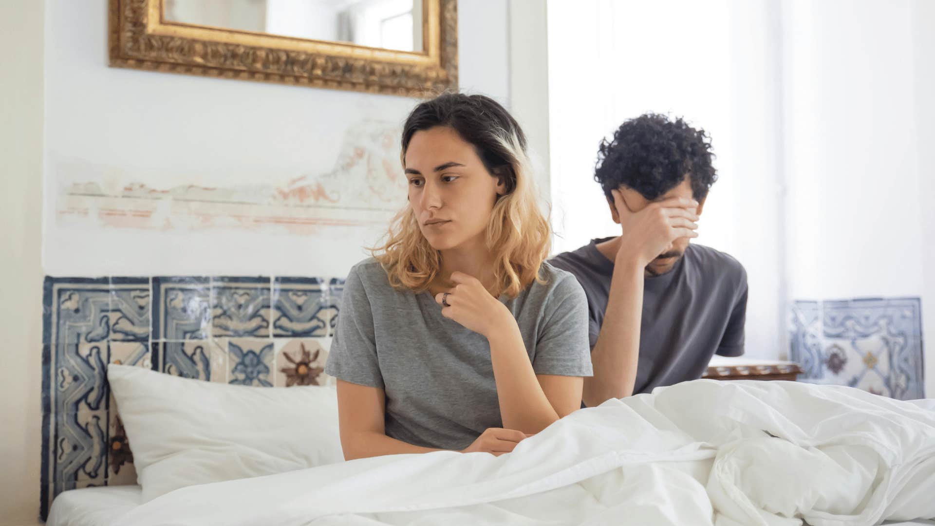 unhappy couple sitting in bed