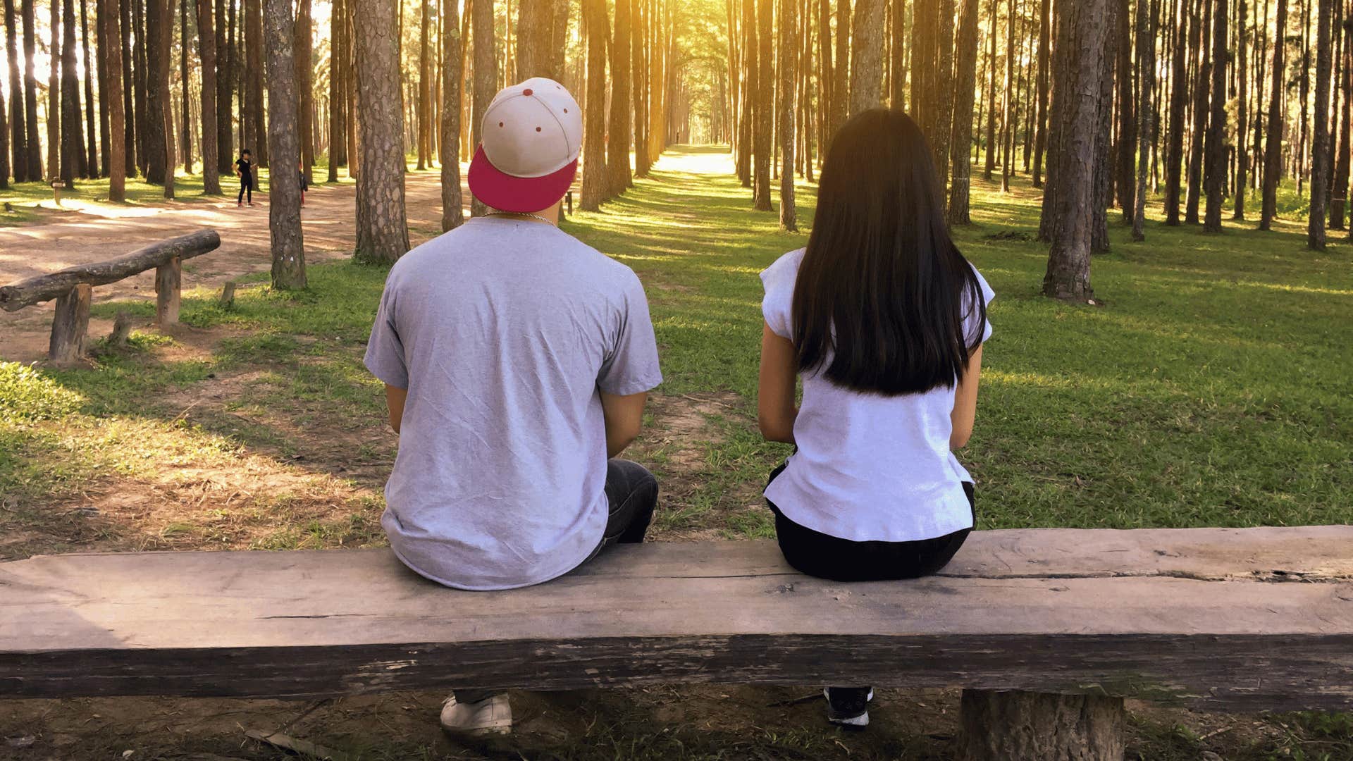 man and woman sitting on outdoor bench