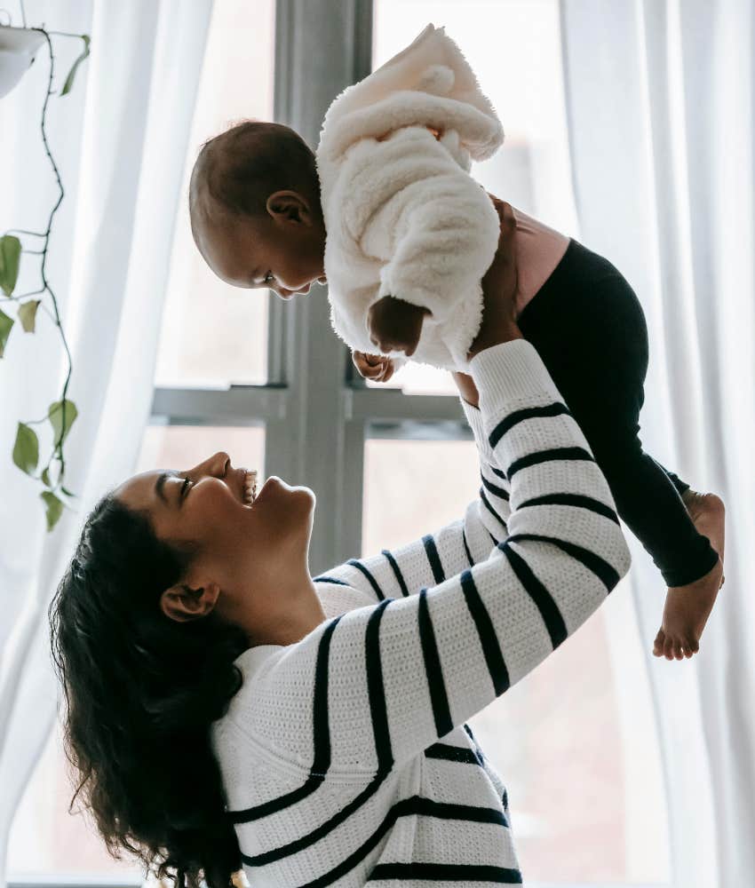 mom holding a baby and smiling