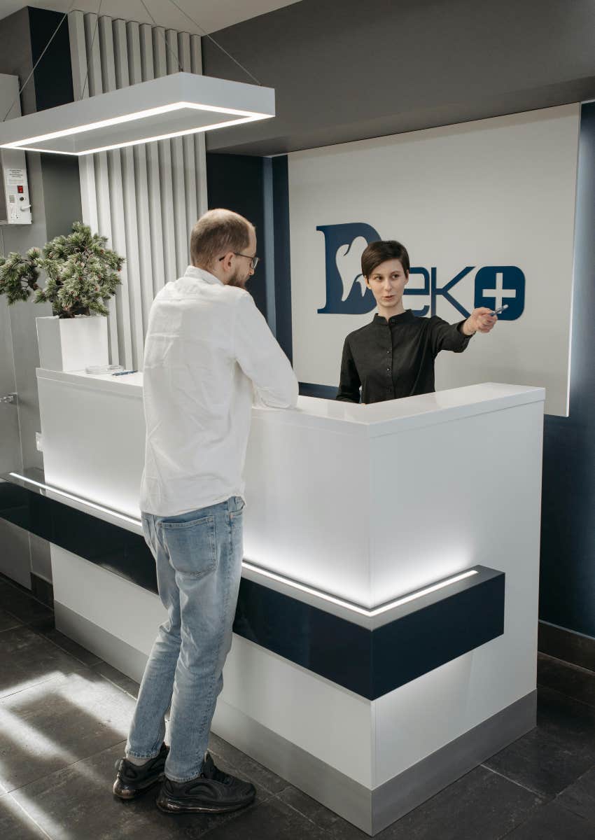 receptionist at dental office talking to man