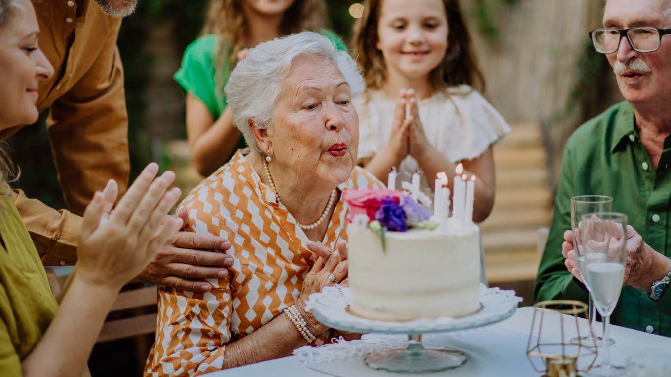 Old woman celebrating her birthday with loved ones. 