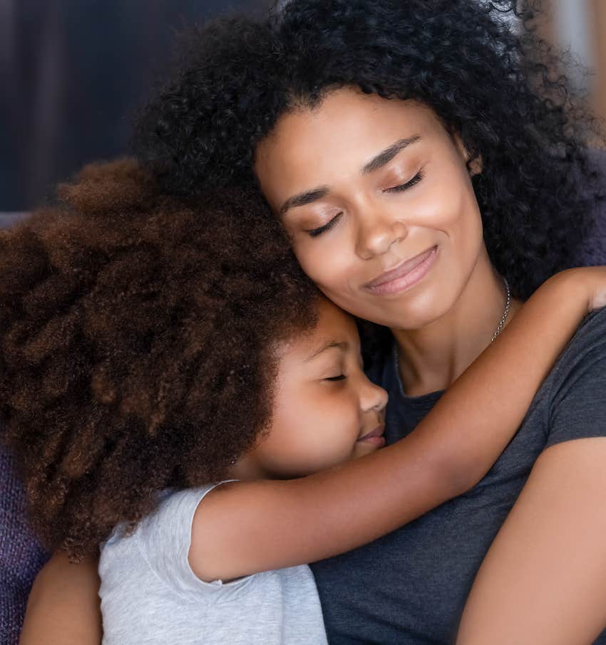 Content child hugs peaceful mother as symbolic of healing self-defeating mindset