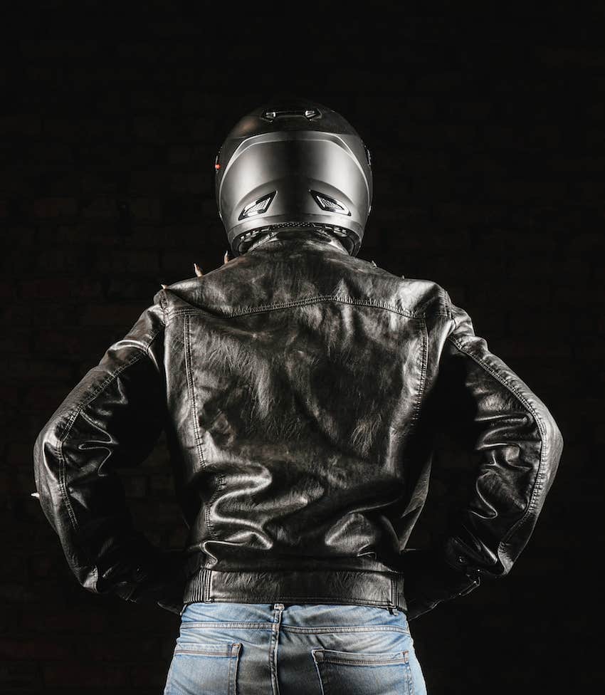 View of the bad boy from behind helmet, leather jacket, jeans