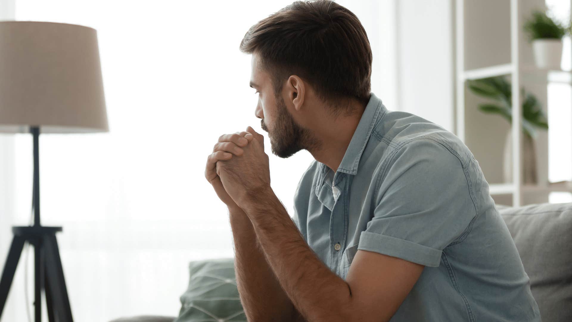 man all alone reflecting and staring out window