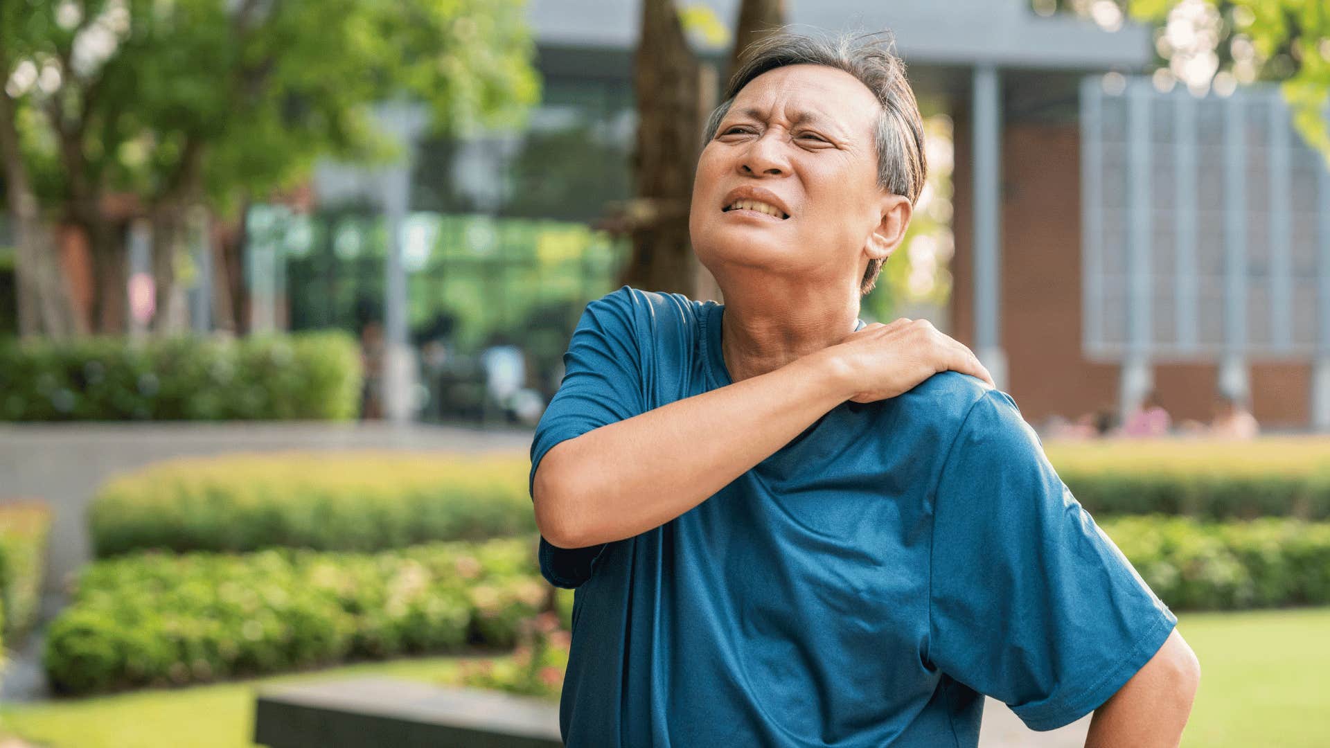 man having a hard time and rubbing shoulder in pain