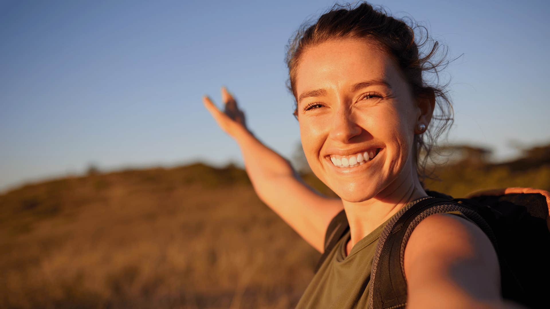 woman outside connecting with universe and smiling