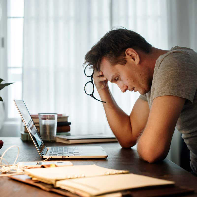 Man stressed while working on laptop