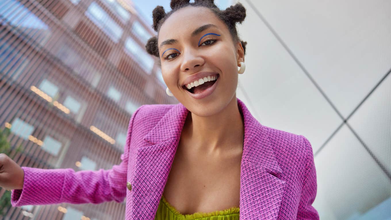 woman with space buns smiling brightly