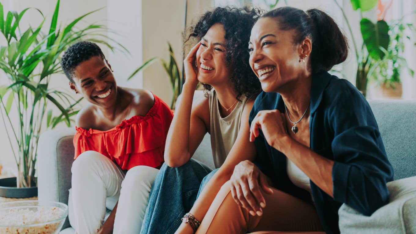 women laughing and sitting on couch together