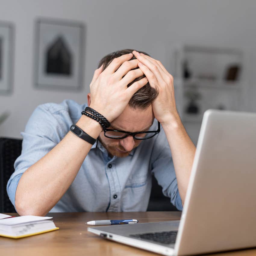 Stressed employee reviewing a sticker chart on his laptop. 