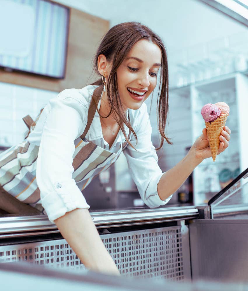 Teen girl scooping ice cream onto a cone for customer