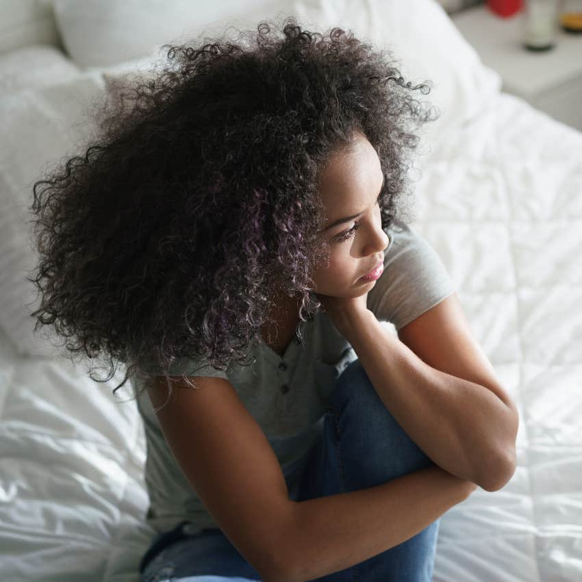 teenager sitting on bed