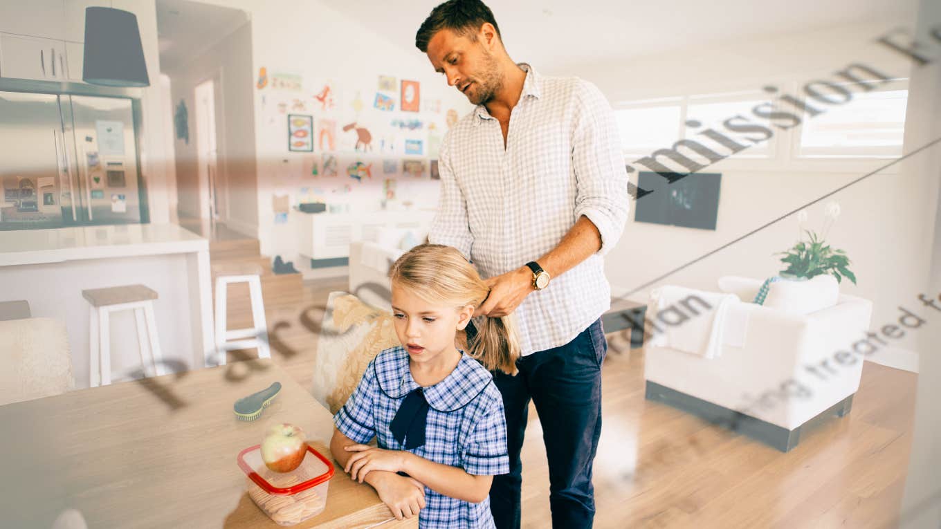 Man getting child ready for school, signing permission slip