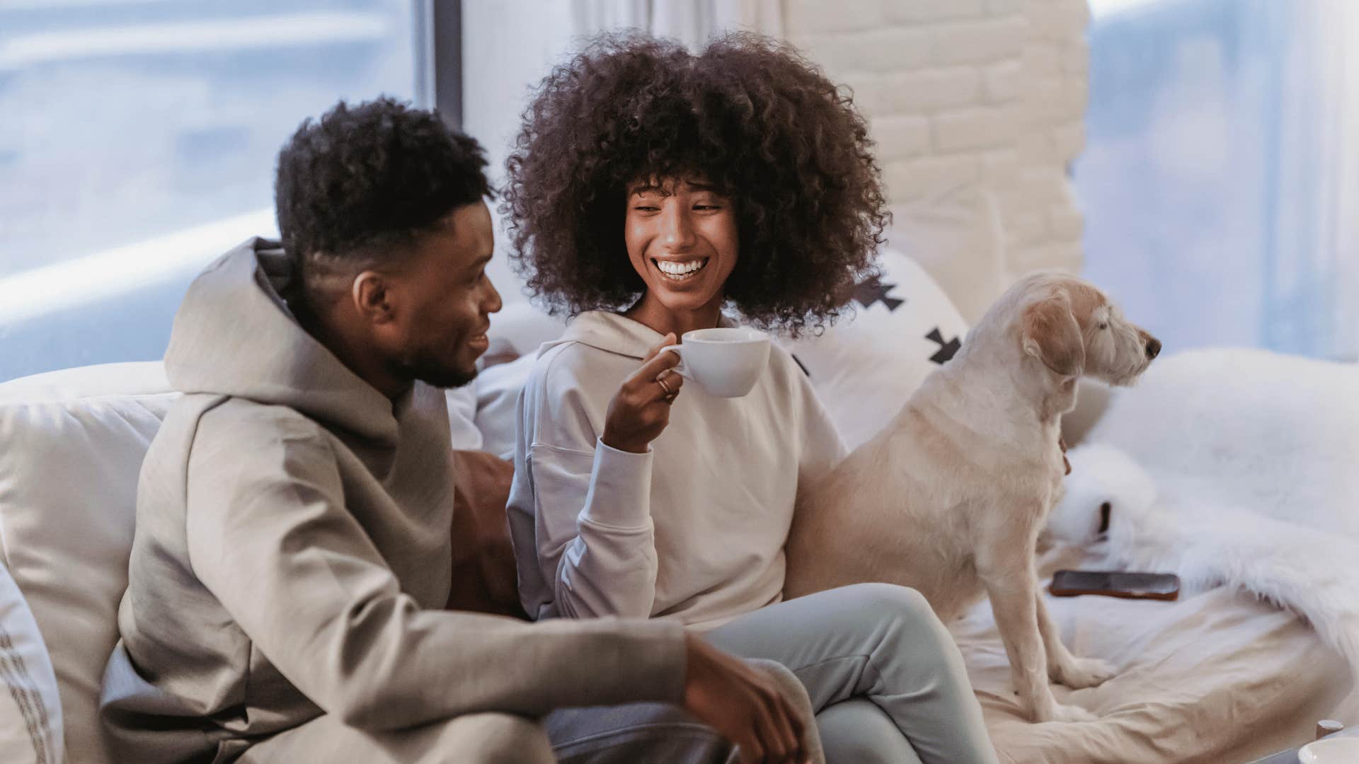 couple relaxing on couch with dog