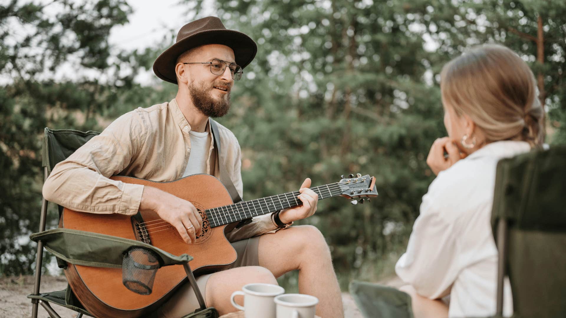 man playing guitar for female partner