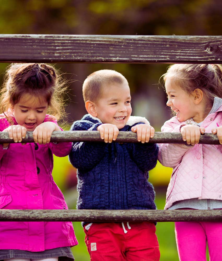 three kids playing on jungle gym