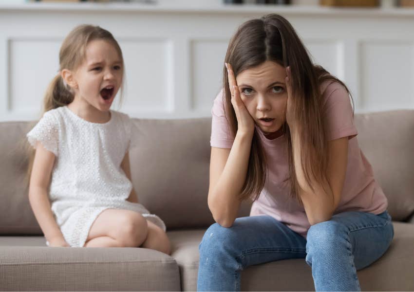 toddler misbehaving and throwing a tantrum with tired older sister at home