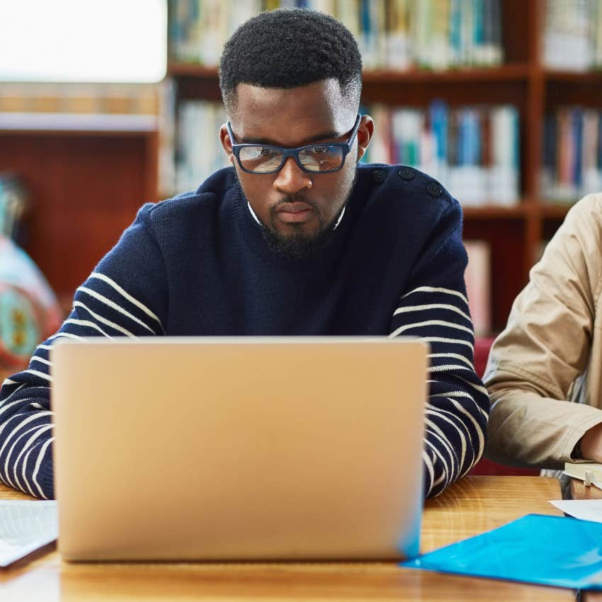 University student writing on their laptop. 