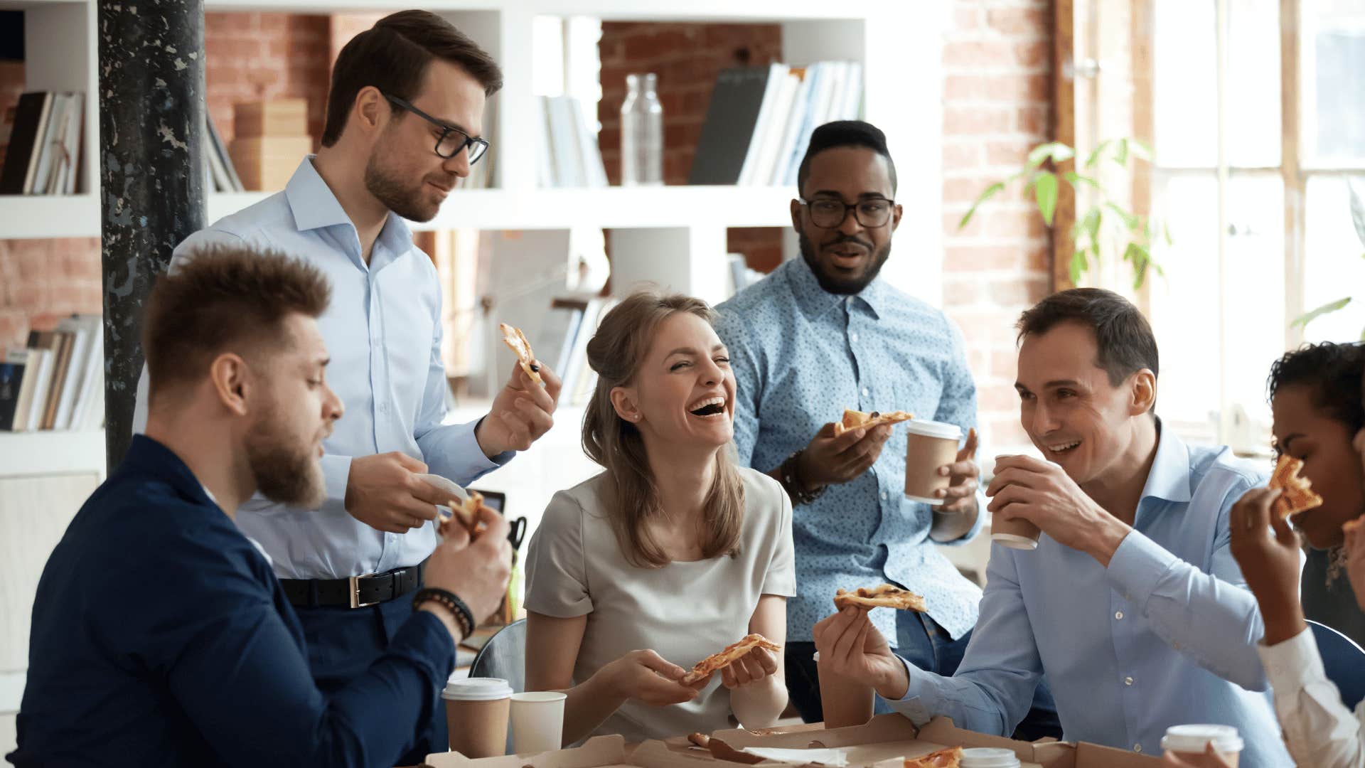 workers laughing and enjoying food together