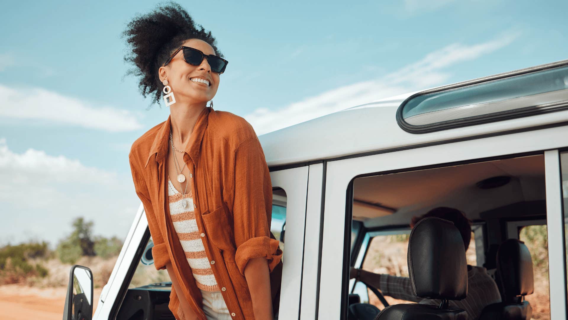 woman hanging out her car window enjoying the breeze