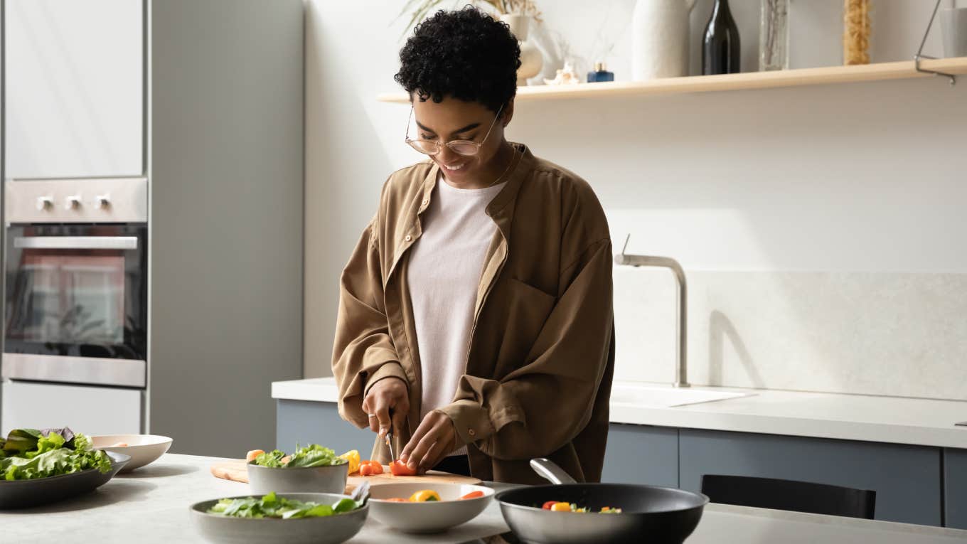 woman cutting food while cooking in kitchen