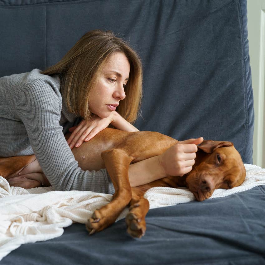 Woman comforting her dog who is getting older