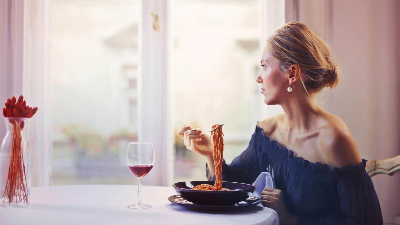 Woman eating pasta at table