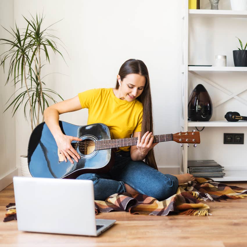 woman learning how to play the guitar