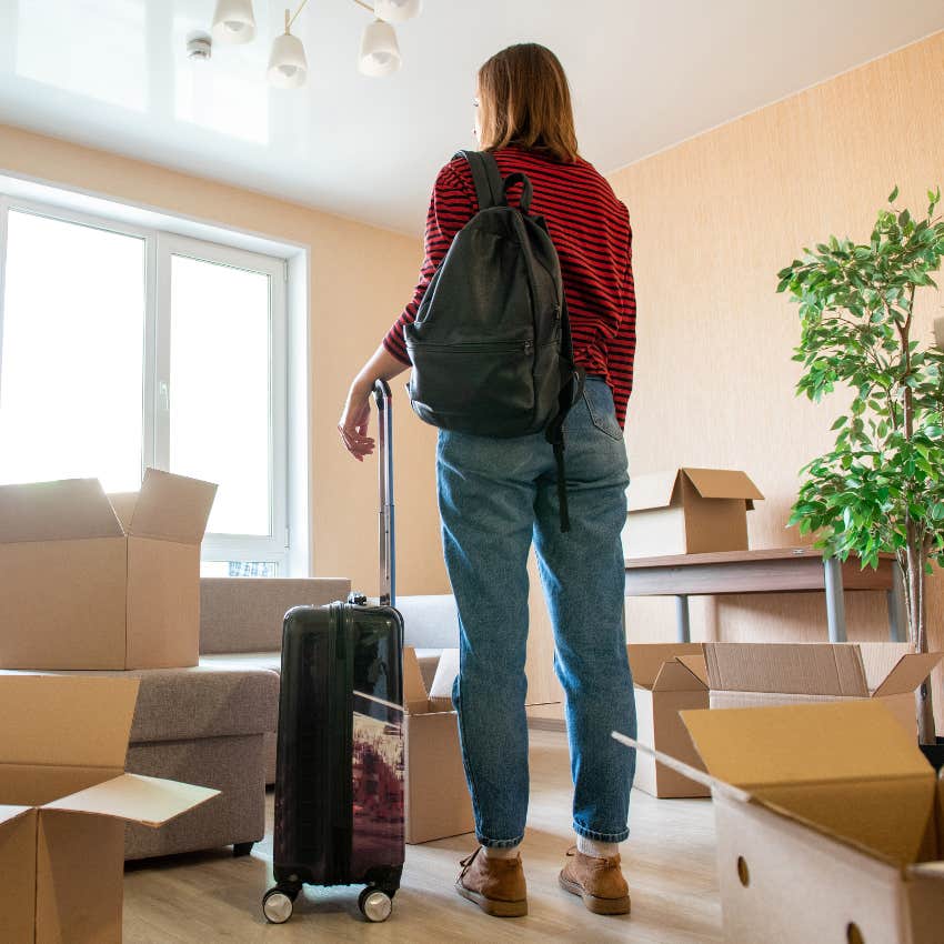 Woman with suitcase and moving boxes