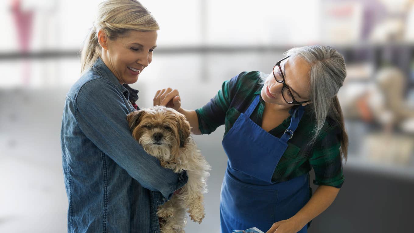 Woman picking up her dog from doggy daycare.