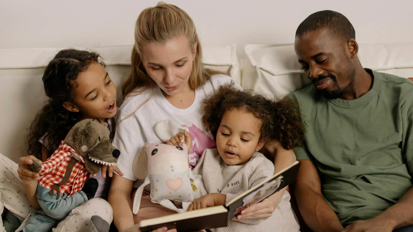 woman and man reading to two kids