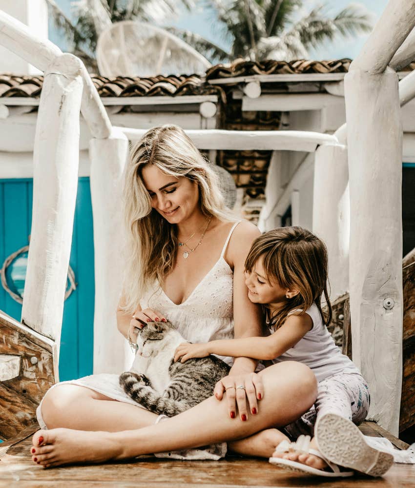 mom and daughter playing with a cat