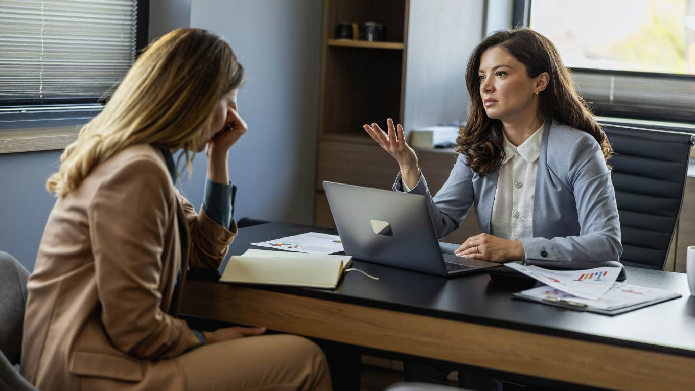 woman being reprimanded at work because her coworkers wives complained about her looks