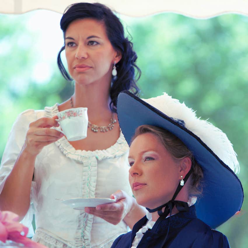 women drinking tea dressed in period garb