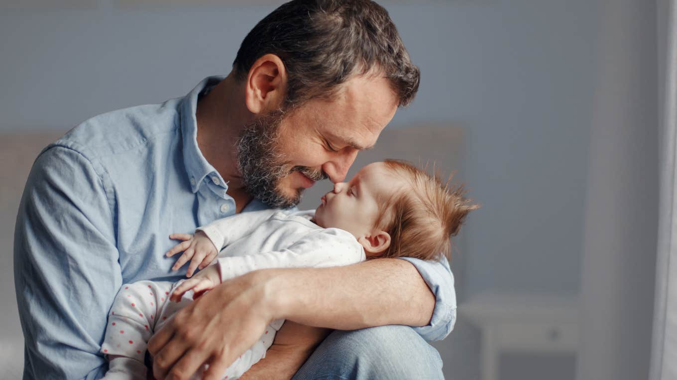 Working dad holding his newborn baby while mother is on maternity leave. 