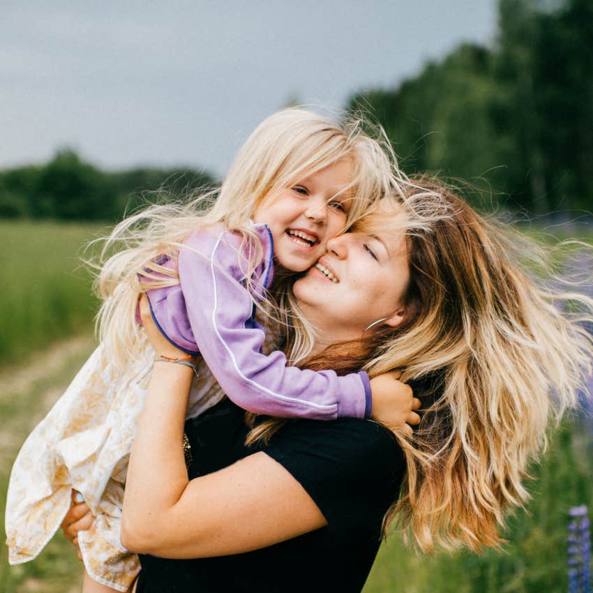 Young daughter hugging her mother. 