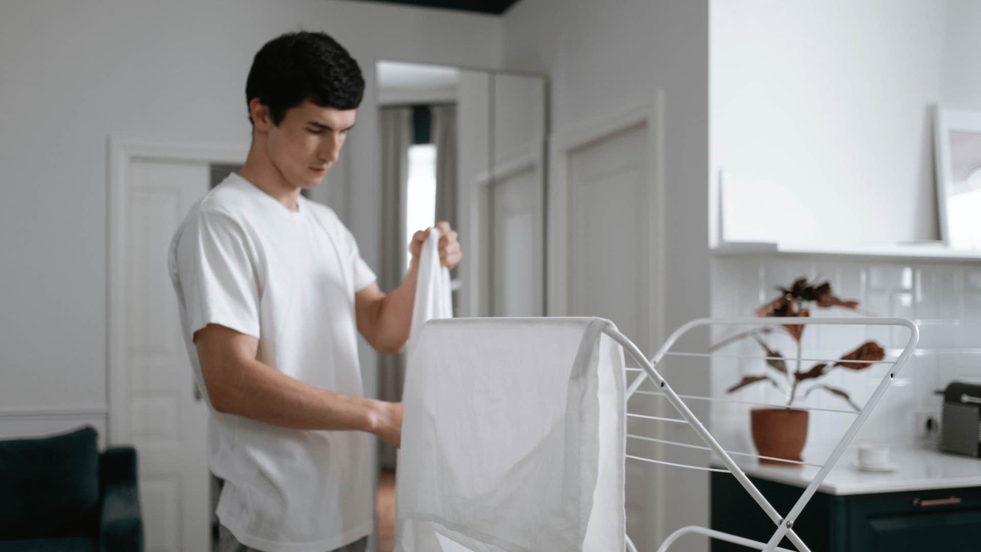 man hanging clothes on rack